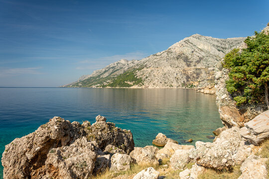 A view of a beach on the Makarska Riviera in Croatia. The beach in the town of Brela. An autumn view of the beach and the azure Adriatic Sea.