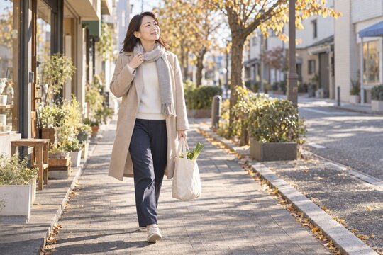 買い物帰りに予想外の暖かさでマフラーを緩める女性