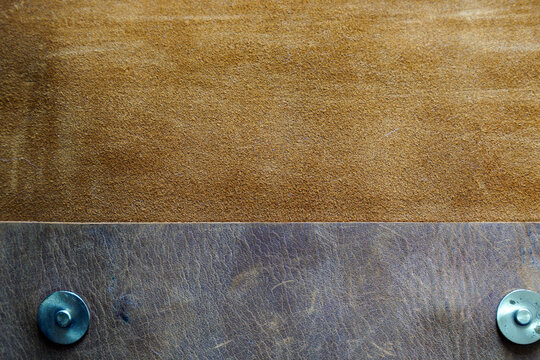 Close-up view of brown leather material with metal fasteners