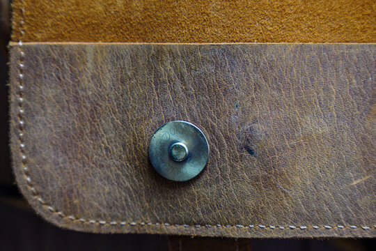 Close-up view of a leather item with a metal button