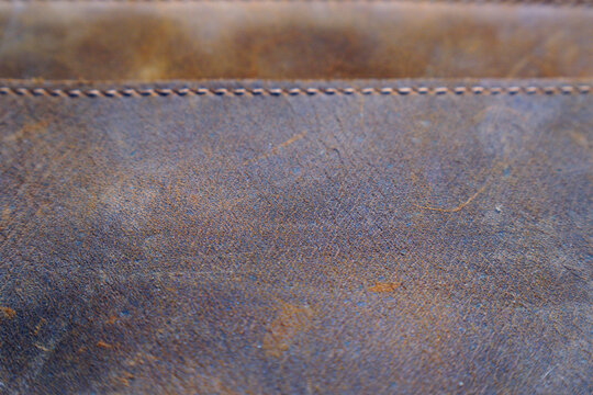 Close-up view of aged leather material with visible stitching