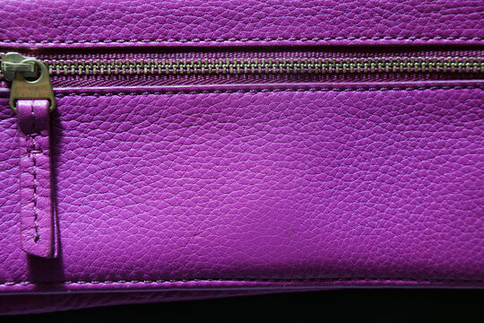 Close-up of vibrant purple leather bag with zipper detail