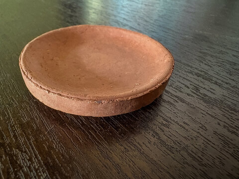 Rustic Terracotta clay saucer on dark wooden table