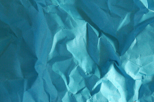 Crinkled turquoise paper with soft folds and texture