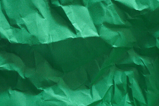 Crinkled green paper with textured surface for various design uses