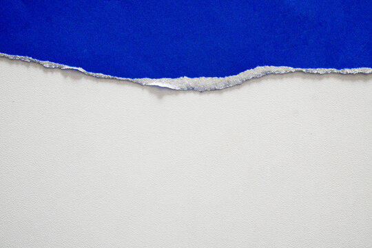 A torn piece of white paper on a blue background