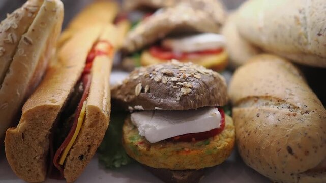 Different types of bread and sandwiches on display at a bakery counter