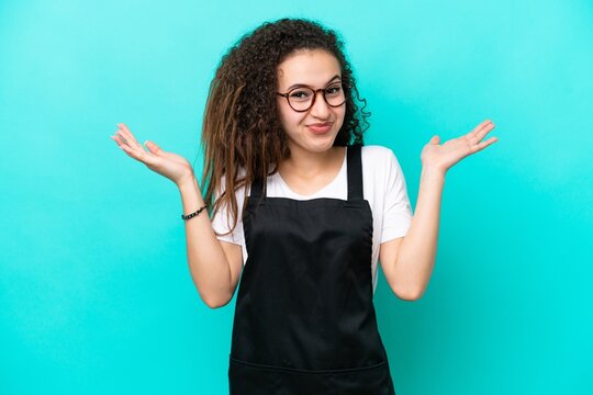 Restaurant waiter Arab woman isolated on blue background having doubts while raising hands