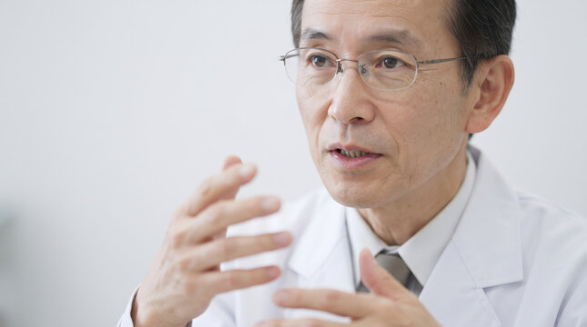 インタビューで熱心に説明するシニアの大学教授・研究者