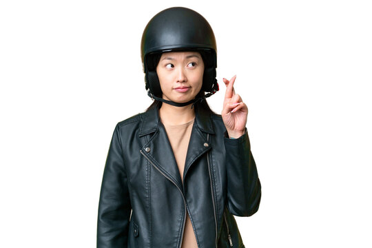Young Asian woman with a motorcycle helmet over isolated chroma key background with fingers crossing and wishing the best