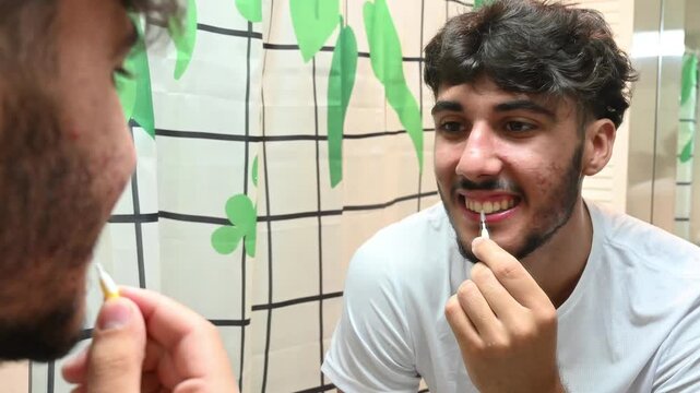 Handsome smiling man using dental floss for oral hygiene