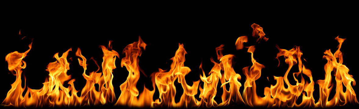 Set of bright orange fire flame plumes burning and blazing along the bottom isolated on black background. Collection of heat, bonfire, and warm light overlay effects for creative designs.