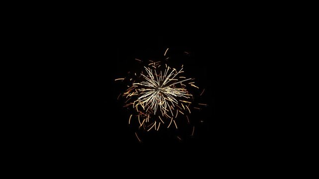 Bright golden sparks explosion isolated on black background, dynamic firework particles glowing in dark night sky motion