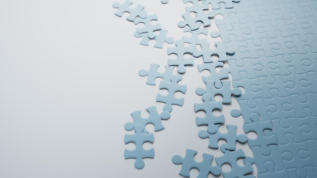 Partially Completed Light Blue and White Jigsaw Puzzle Background with scattered Pieces. Planning Concept with copy-space.