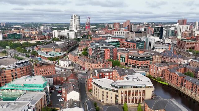 Aerial view of Leeds city center with river aire and modern architecture on cloudy day.