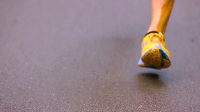 Close up of marathon athletes legs and feet running on pavement