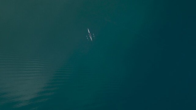 An aerial view of the two rowing a boat on the lake