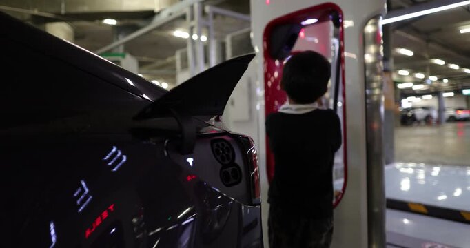 Little boy enjoy use EV car charge indoor supermarket car park transport technology