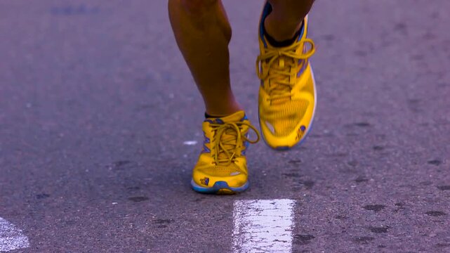 Close up of ultra runners legs while jogging on the pavement