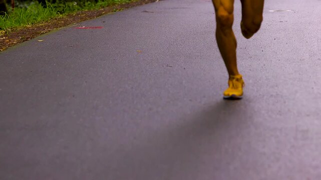Close up of ultra runners legs and feet jogging on the asphalt