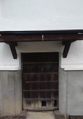 Traditional Japanese kura storehouse wooden door with white plaster wall © 章弘 塩月