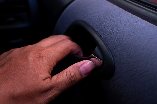 Passenger hand pulling chrome interior door handle mechanism to open the car door from inside.