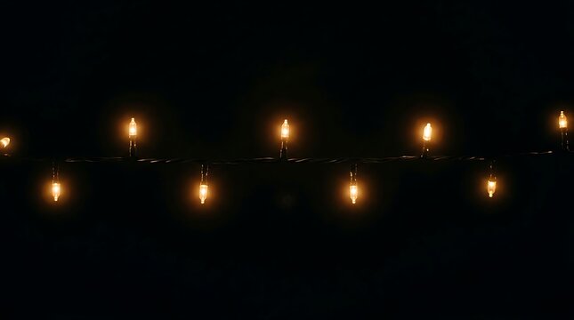 Warm glowing light bulb on dark wire