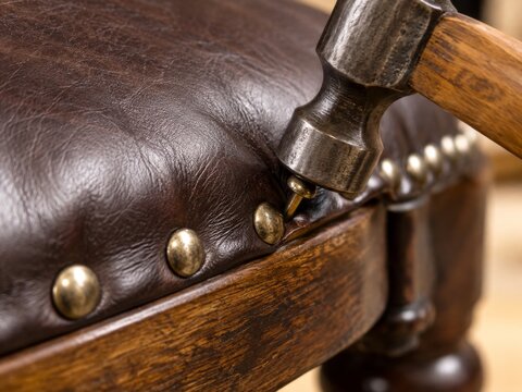 Proceso de reparaci&oacute;n de un sill&oacute;n con clavos y martillo