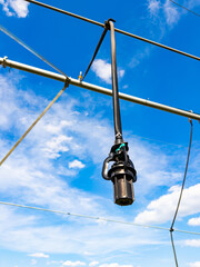 Obraz premium Hanging irrigation system on a sunny day. A hanging irrigation system is installed from pipes in the sky. The blue sky has clouds in the background.