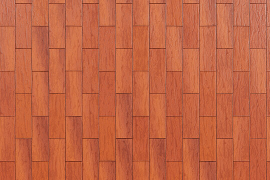 Texture di pavimento in legno rossastro-ambrato con assi verticali sfalsate simili a un decking. Ideale come sfondo per pavimenti, terrazze o rivestimenti.