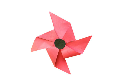Red paper pinwheel with black center for child play and craft projects.