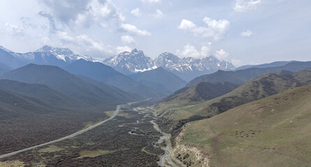 Snow-capped mountains above a winding river valley in a remote highland landscape © PhanThi
