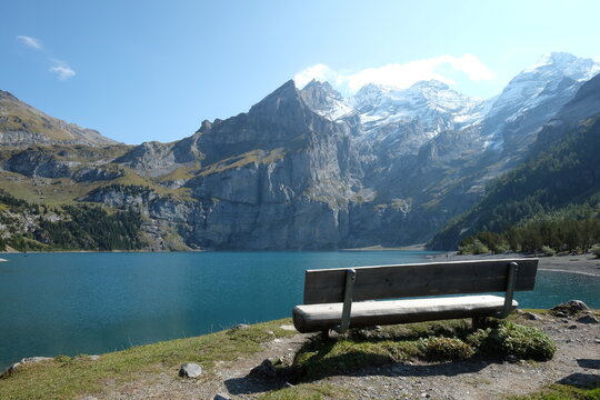Empty bench overlooking alpine lake in Oeschinensee