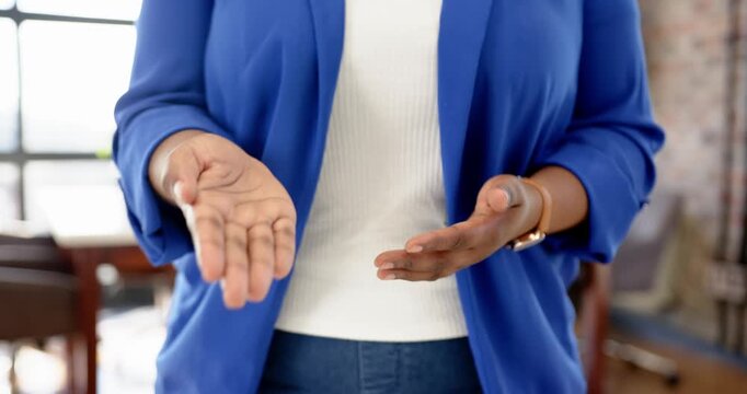 Close up of people talking to the camera, clasping hands, woman in blue blazer standing in office en
