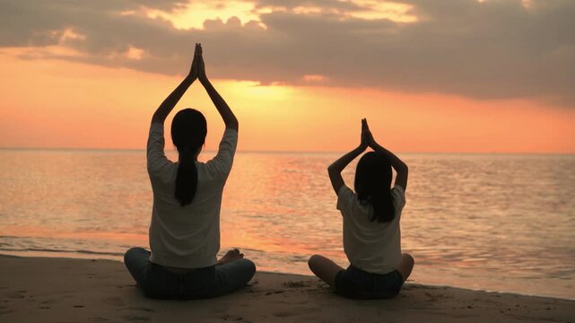 back view Woman daughter girl practicing meditation in sandy ocean beach in sunset sunrise, Relaxation recovery vitality, healthy lifestyle for stay beautiful, trip sea summer vacation, yoga practice