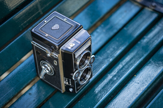 Vintage twin-lens reflex camera on wooden bench