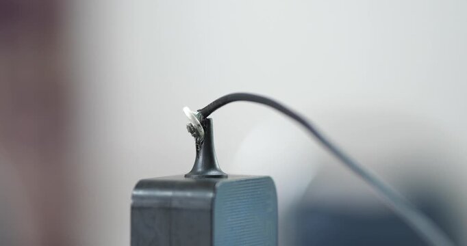 Close up of damaged power adapter cable with broken frayed wire