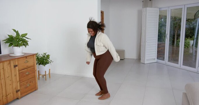High speed photography for dynamic scenes, smiling woman jumping indoors, wearing casual outfit in m