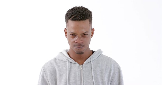 Wearing gray hoodie, man looking down with focused expression against white backdrop