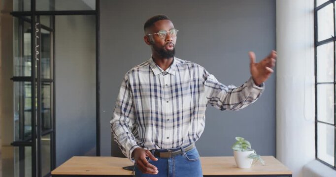 Giving presentation with enthusiasm and confidence, businessman in office setting