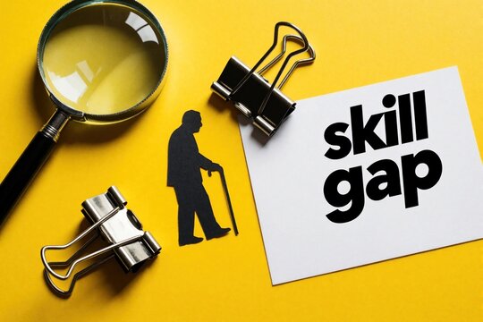 Man with walking cane silhouette on yellow background. Magnifying glass, paper clips lay near note with skill gap text. Concept shows difficulty finding right talent facing employment challenges in