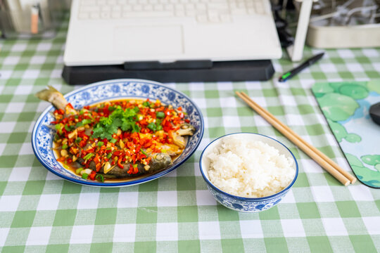 Chinese meal on the computer desk&mdash;braised yellow croaker with white rice.