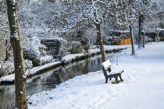park bench near river in winter
