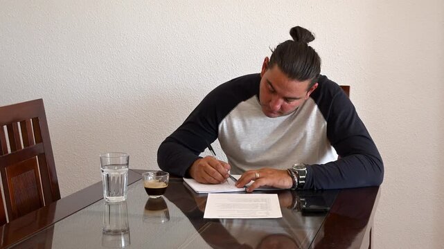 Man sitting at glass table signing contract agreement