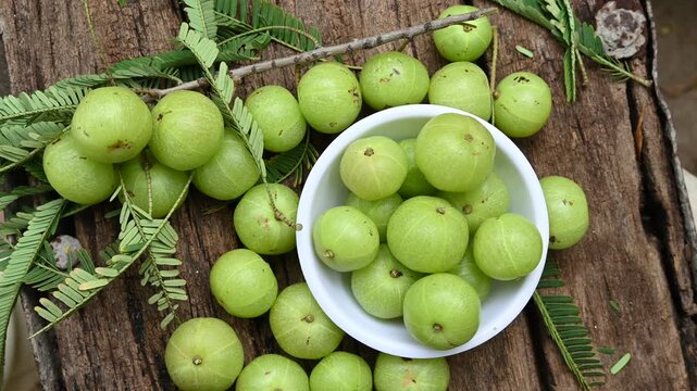 Fresh Amla (Indian gooseberry) fruits on wooden table background
