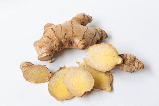 Fresh ginger root with ginger slices isolated on a white background. Sliced ginger. Close-up ginger root.