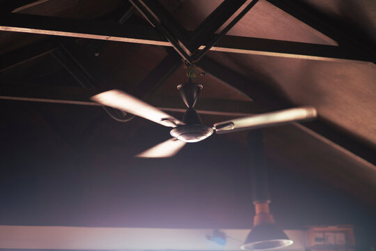 Ceiling cooler propeller on a wooden roof in a domestic scene
