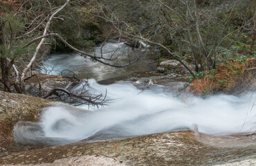 Remolinos en un arroyo de aguas frías fluyendo entre rocas. Paisaje en larga exposición. Sierra de Guadarrama, arroyo del Chorro en San Mamés, Madrid, España. © AngelLuis