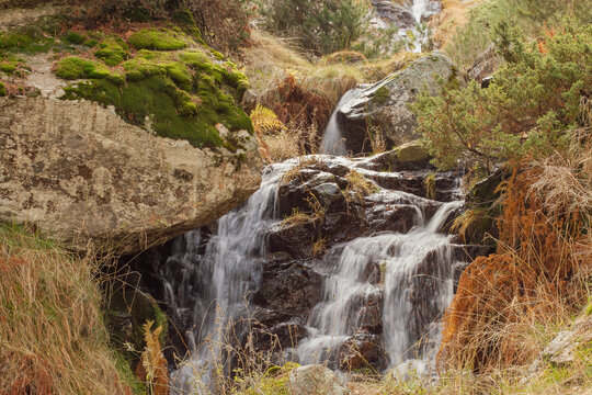Arroyo de aguas fr&iacute;as que nace en la monta&ntilde;a y fluye entre rocas en oto&ntilde;o. Sierra de Guadarrama, arroyo del Reajo Bajo en San Mam&eacute;s, Madrid, Espa&ntilde;a.