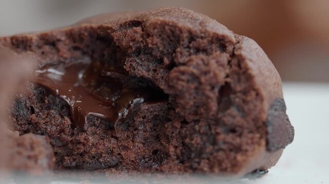Close up slow motion footage of melting chocolate oozing from a decadent brownie cookie.